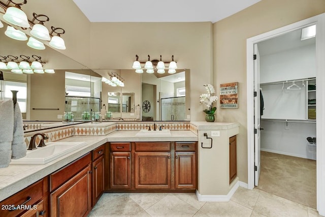 12903 W Brookhart Way, Peoria, AZ 85383 - bathroom with a stall shower, double vanity, a walk in closet, and tile patterned flooring