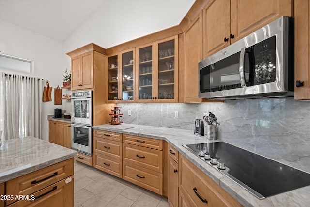 2243 E Cortez Dr, Gilbert, AZ 85234 - kitchen with appliances with stainless steel finishes, lofted ceiling, backsplash, light stone counters, and glass insert cabinets