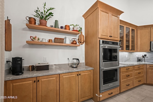 2243 E Cortez Dr, Gilbert, AZ 85234 - kitchen with stainless steel appliances, open shelves, light stone counters, backsplash, and glass insert cabinets