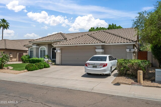 2243 E Cortez Dr, Gilbert, AZ 85234 - mediterranean / spanish-style house featuring a garage, concrete driveway, a tile roof, and stucco siding