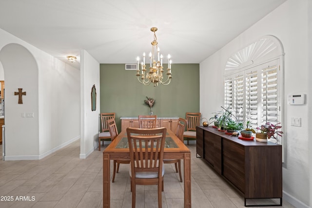 2243 E Cortez Dr, Gilbert, AZ 85234 - dining area featuring a chandelier, arched walkways, baseboards, and light tile patterned flooring