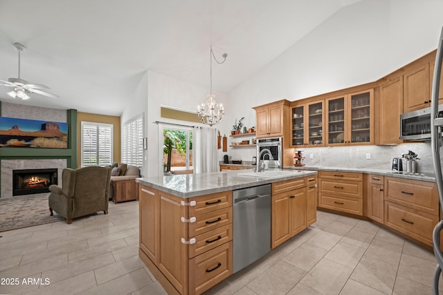 2243 E Cortez Dr, Gilbert, AZ 85234 - kitchen featuring appliances with stainless steel finishes, a sink, backsplash, a fireplace, and an island with sink