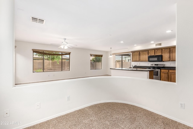 kitchen featuring sink, carpet floors, decorative light fixtures, stainless steel range with electric stovetop, and ceiling fan