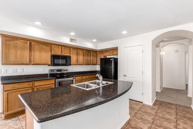 kitchen featuring black appliances, light tile patterned floors, a kitchen island with sink, and sink