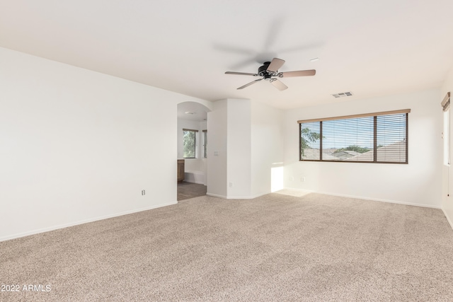 carpeted empty room featuring ceiling fan and a wealth of natural light