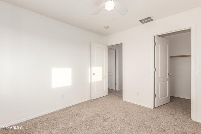 unfurnished bedroom with light carpet, a closet, and ceiling fan