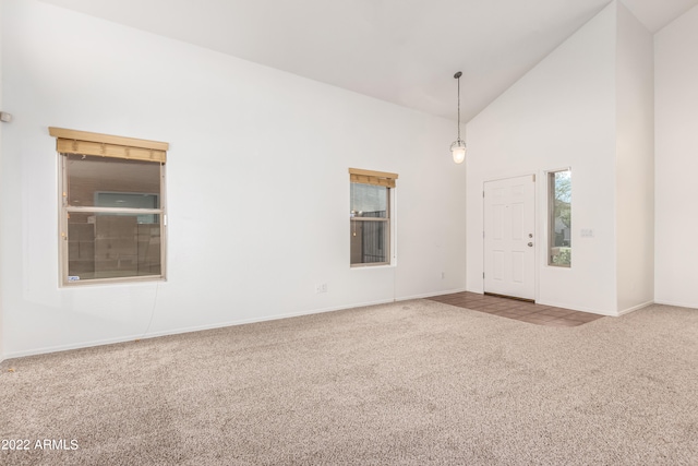 unfurnished room with high vaulted ceiling and carpet floors