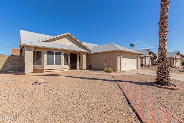 ranch-style house with a garage, driveway, and stucco siding