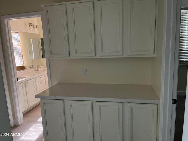 kitchen with sink, white cabinetry, and light hardwood / wood-style floors