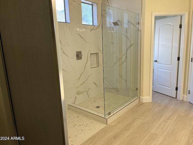 bathroom featuring a shower with door and wood-type flooring