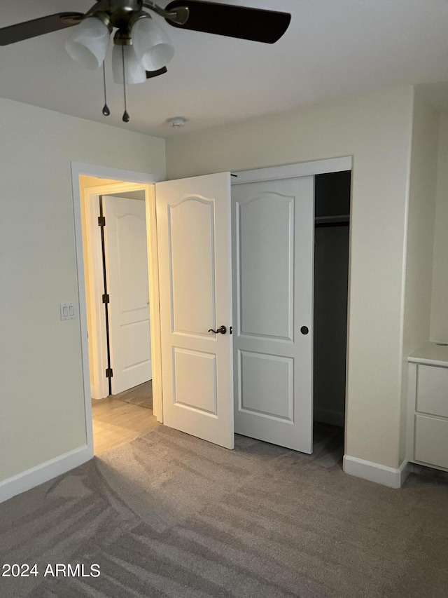 unfurnished bedroom featuring a closet, ceiling fan, and light carpet