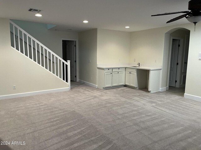 carpeted empty room with sink and ceiling fan