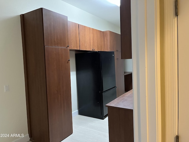 kitchen with black fridge and light hardwood / wood-style floors