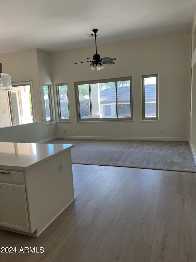 kitchen with ceiling fan, light hardwood / wood-style flooring, and white cabinetry