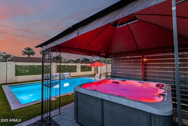 8522 E Virginia Ave, Scottsdale, AZ 85257 - pool at dusk featuring a hot tub, a gazebo, a fenced backyard, and a patio area