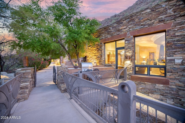 patio terrace at dusk featuring area for grilling