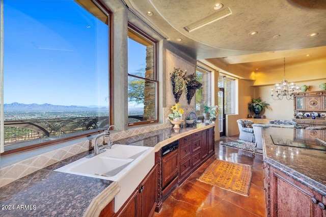 kitchen with a mountain view, sink, decorative light fixtures, dark tile patterned floors, and a notable chandelier