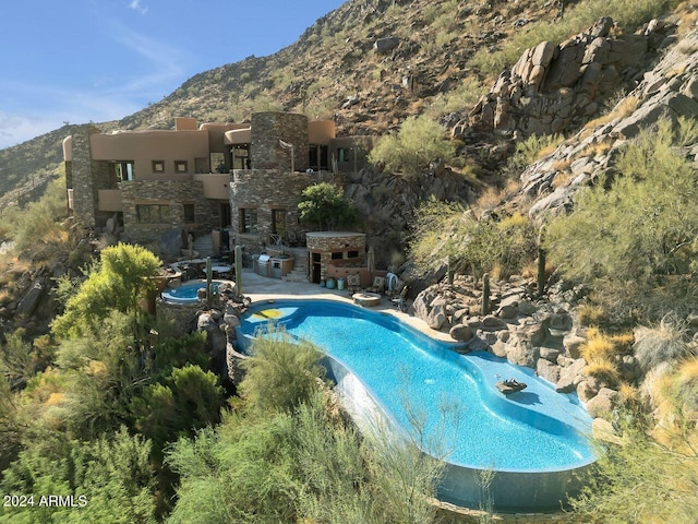 view of swimming pool with a mountain view and a patio area