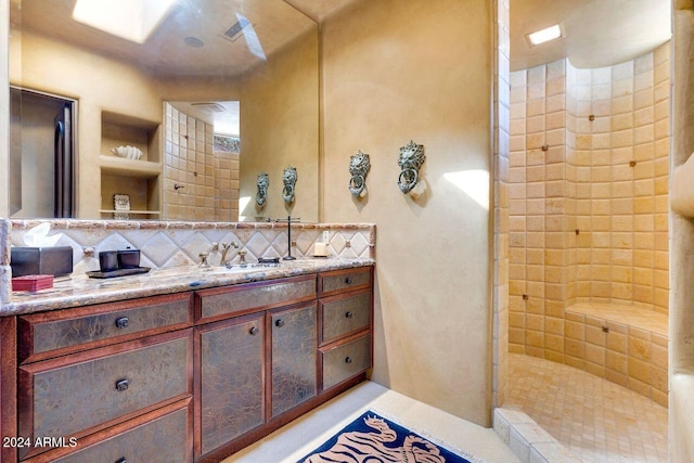 bathroom featuring a tile shower, tasteful backsplash, and vanity