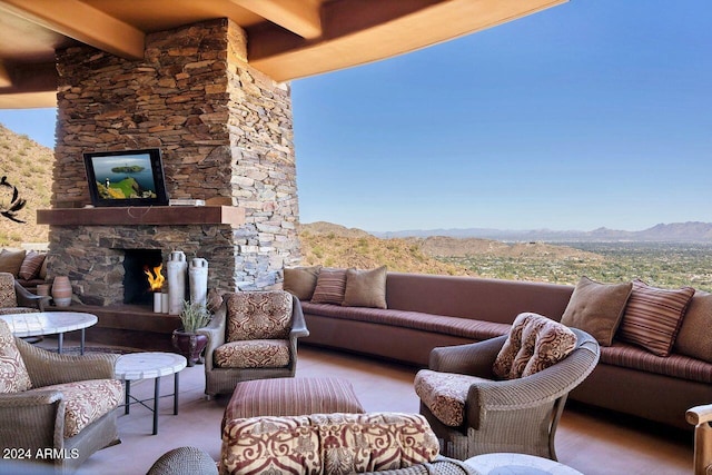 view of patio with an outdoor living space with a fireplace and a mountain view