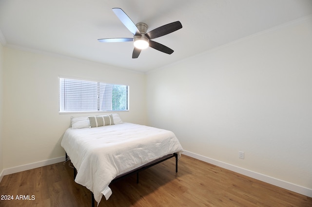 bedroom with ceiling fan, crown molding, and hardwood / wood-style floors