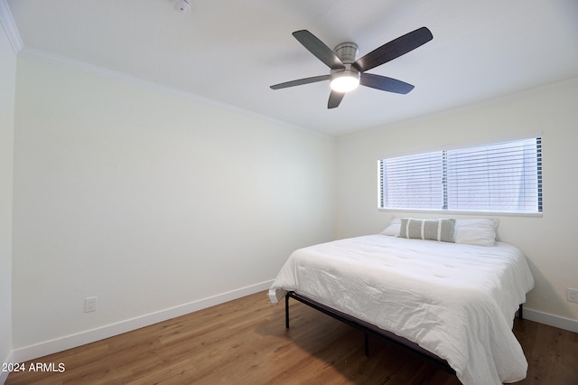 bedroom featuring ceiling fan, ornamental molding, and hardwood / wood-style floors