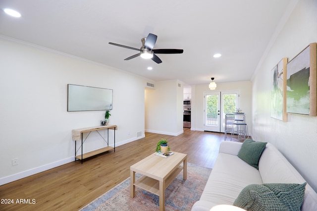 living room featuring ceiling fan, wood-type flooring, and ornamental molding