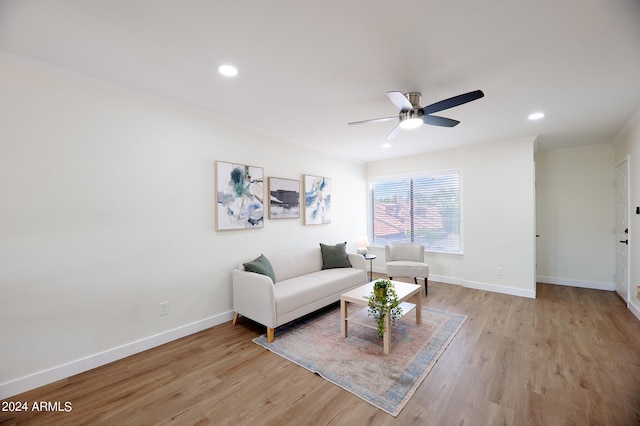 living room featuring ceiling fan, ornamental molding, and light hardwood / wood-style flooring