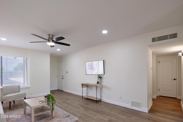 sitting room featuring ceiling fan, ornamental molding, and wood-type flooring