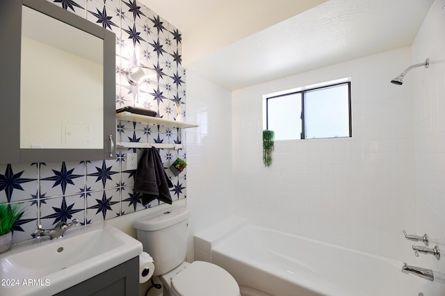 full bathroom featuring toilet, tiled shower / bath, backsplash, and vanity