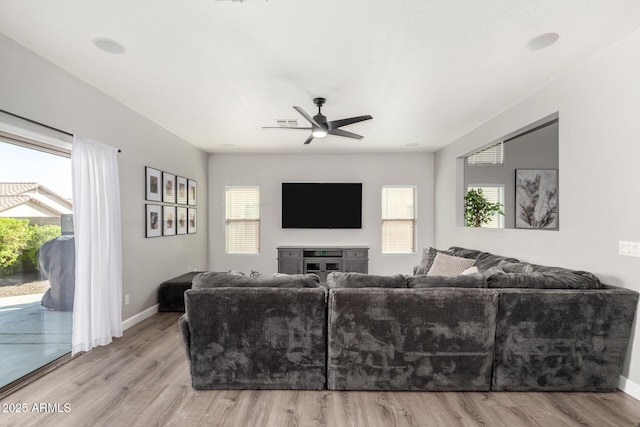 living room featuring a wealth of natural light, baseboards, and wood finished floors