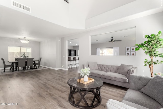 living area featuring a wealth of natural light, visible vents, and wood finished floors