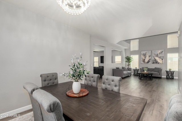 dining room with baseboards, an inviting chandelier, and wood finished floors