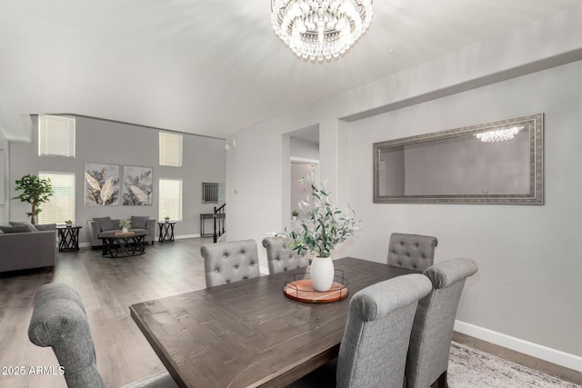 dining space with wood finished floors, baseboards, and a chandelier