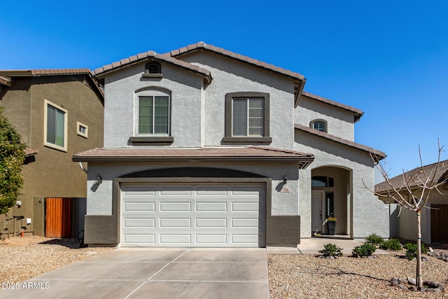 view of front of home with a tiled roof, stucco siding, an attached garage, and concrete driveway