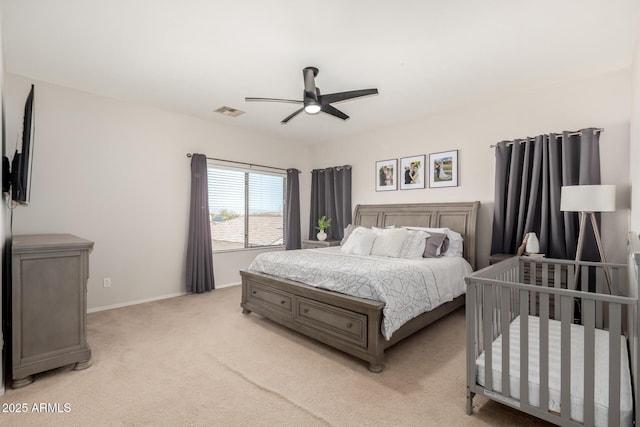 bedroom featuring a ceiling fan, light colored carpet, visible vents, and baseboards