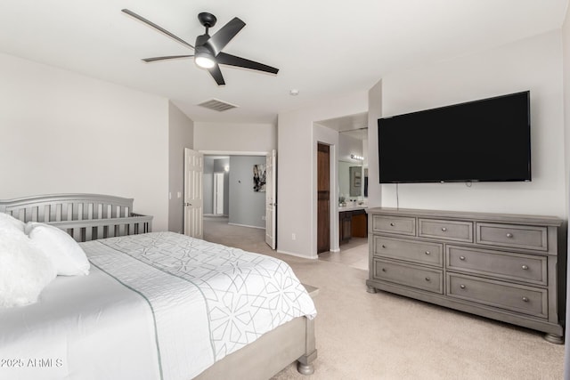 bedroom featuring visible vents, light colored carpet, a ceiling fan, and connected bathroom