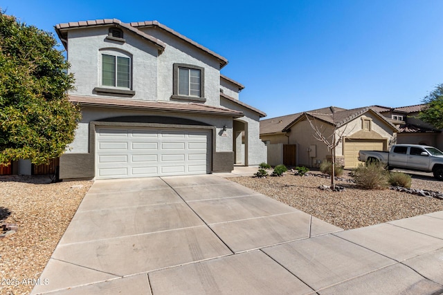 traditional home featuring stucco siding, an attached garage, driveway, and a tile roof