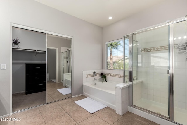 bathroom with baseboards, recessed lighting, tile patterned flooring, a shower stall, and a garden tub