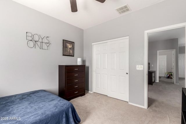 bedroom featuring visible vents, a closet, baseboards, light colored carpet, and ceiling fan