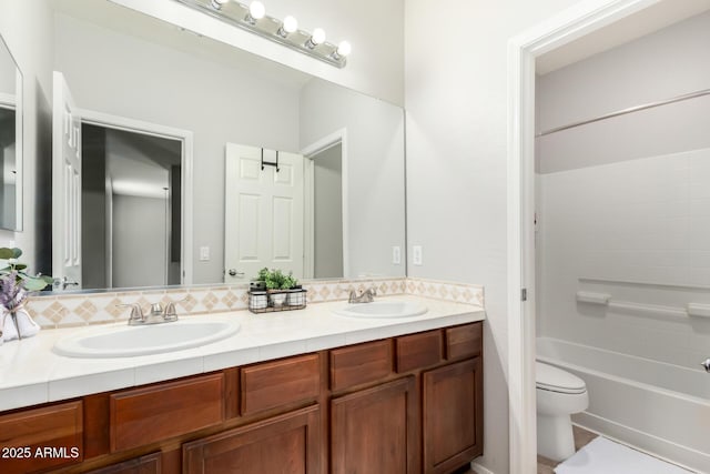 full bath with a sink, toilet, shower / washtub combination, and double vanity