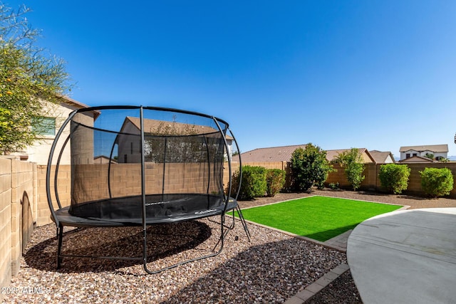 view of yard with a patio, a trampoline, and a fenced backyard