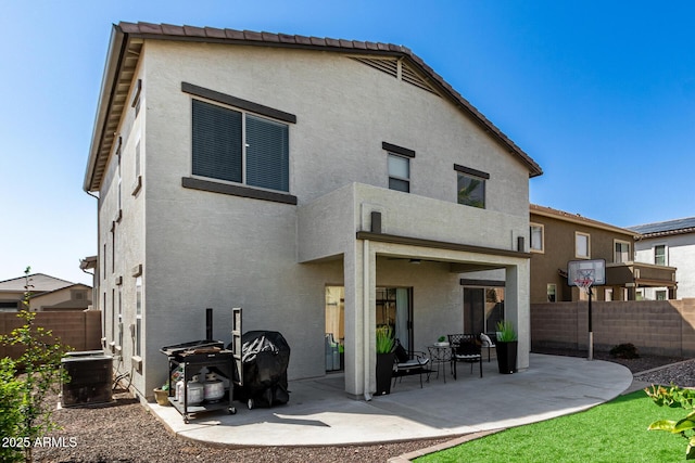 rear view of house featuring central air condition unit, a fenced backyard, and stucco siding