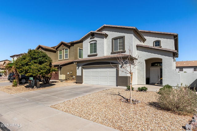 view of front of property with a garage, a tile roof, driveway, and stucco siding