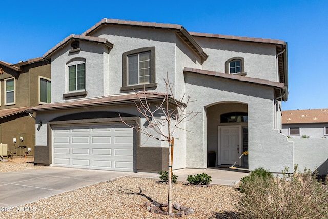 view of front of house with a tiled roof, a garage, driveway, and stucco siding