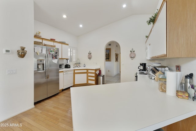 kitchen featuring white appliances, vaulted ceiling, and white cabinets