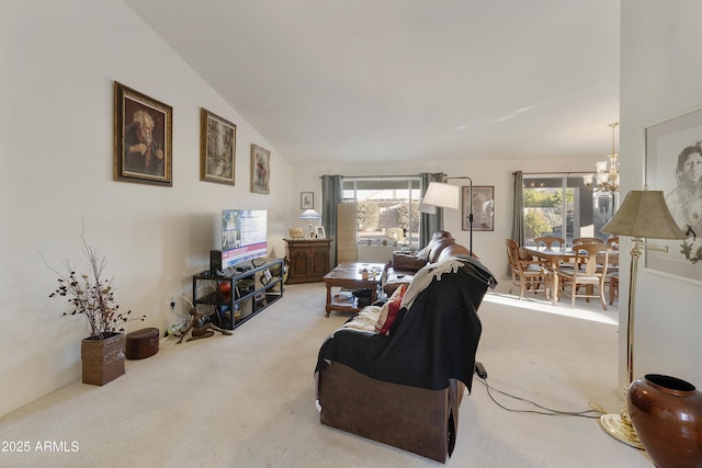 carpeted living room featuring a healthy amount of sunlight, vaulted ceiling, and a notable chandelier