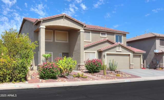 mediterranean / spanish-style home with driveway, a tiled roof, a garage, and stucco siding