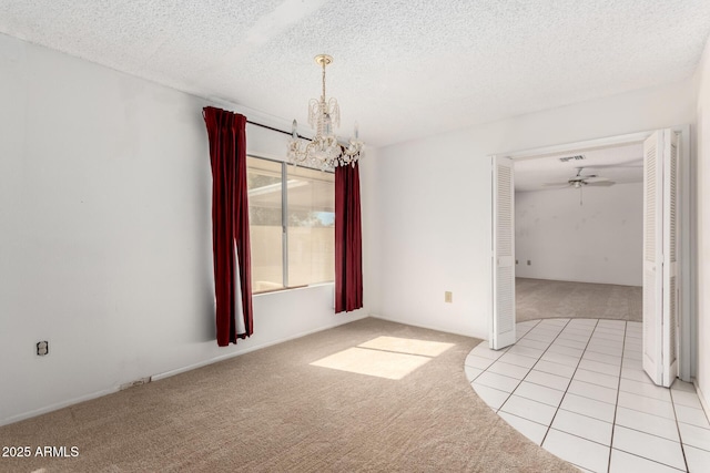 unfurnished room featuring light colored carpet, ceiling fan with notable chandelier, and a textured ceiling