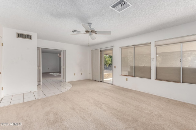 carpeted spare room with a textured ceiling and ceiling fan